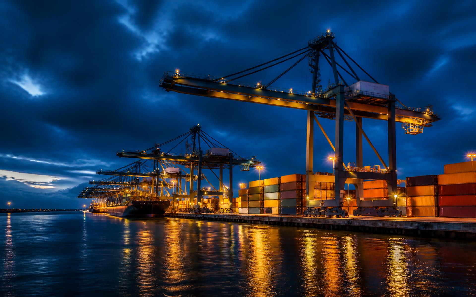 European container port at blue hour with illuminated cranes